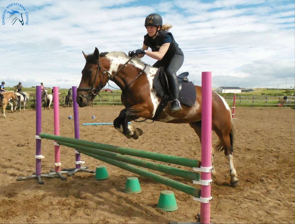 Student show jumping with horse