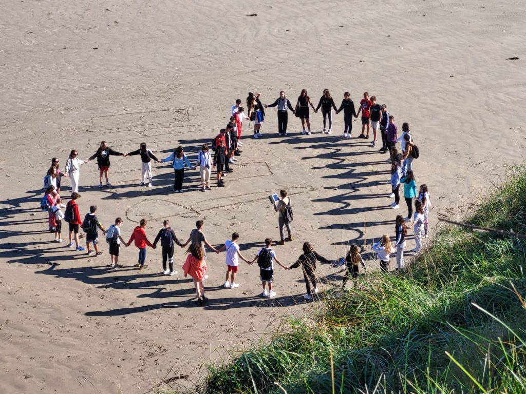 Students on Bundoran beach creating a heart
